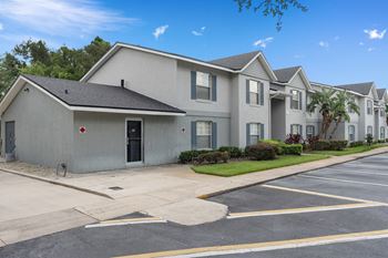 A white house with a street and a parking lot